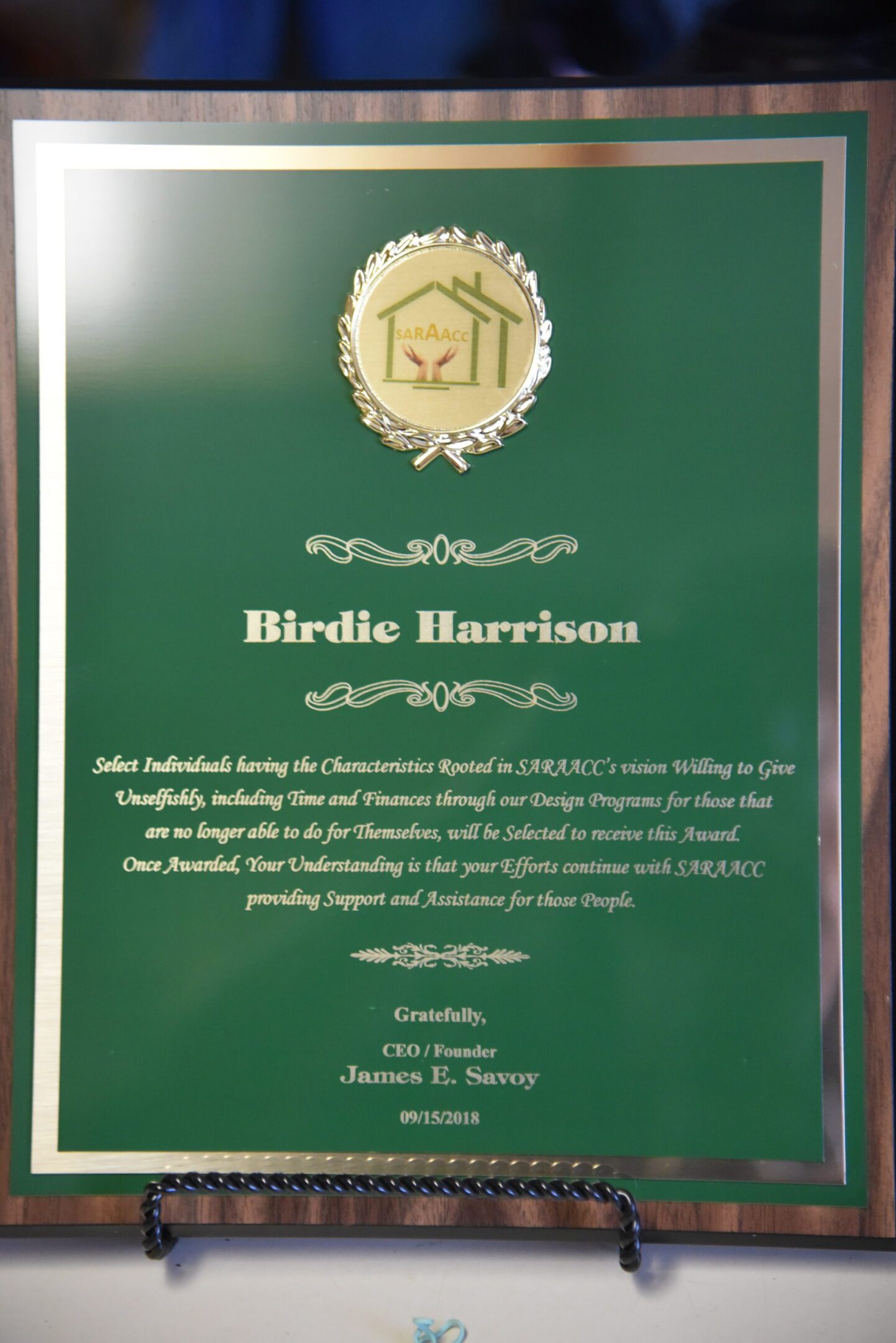 Green award plaque with decorative text.