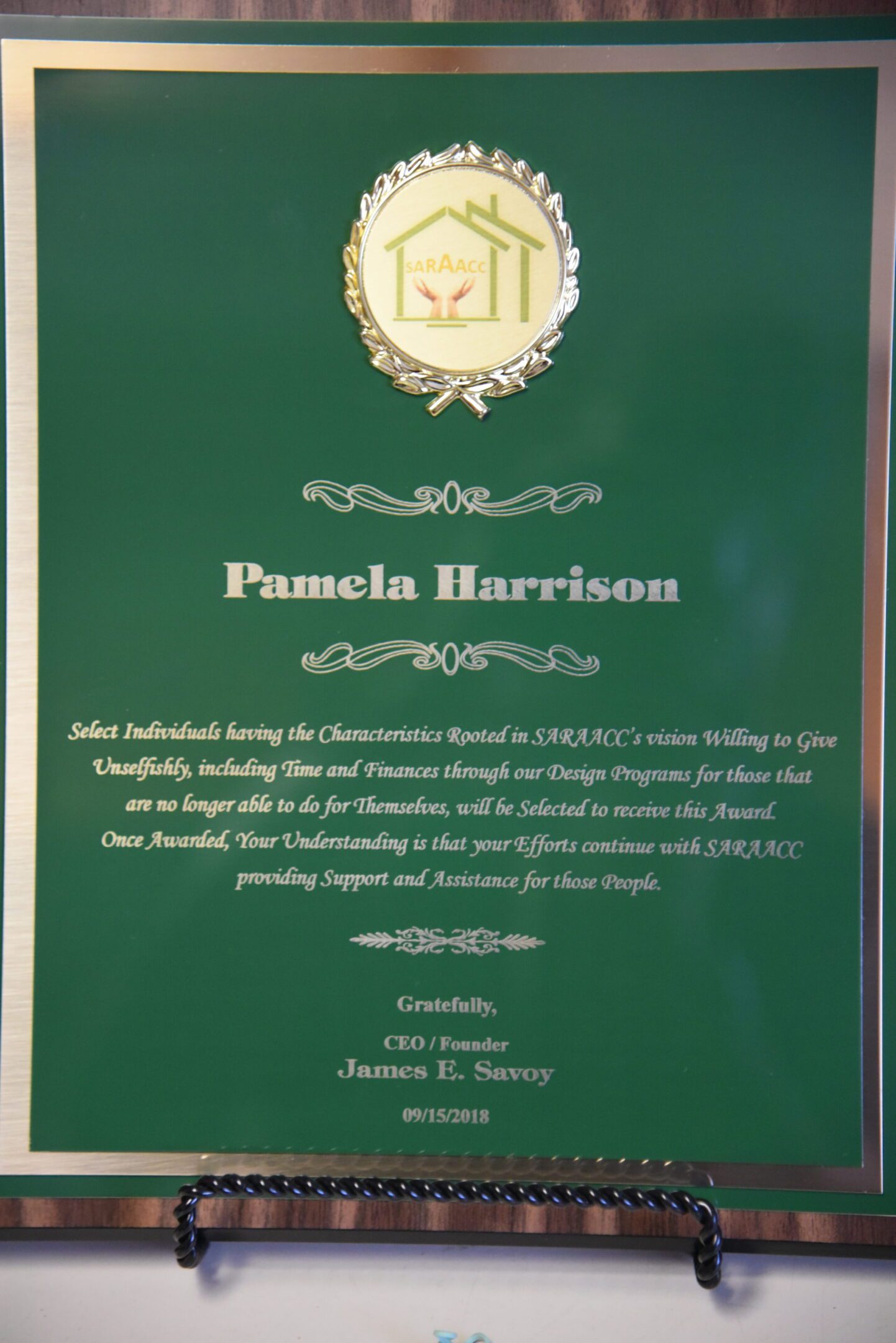 Green award plaque with text and logo.