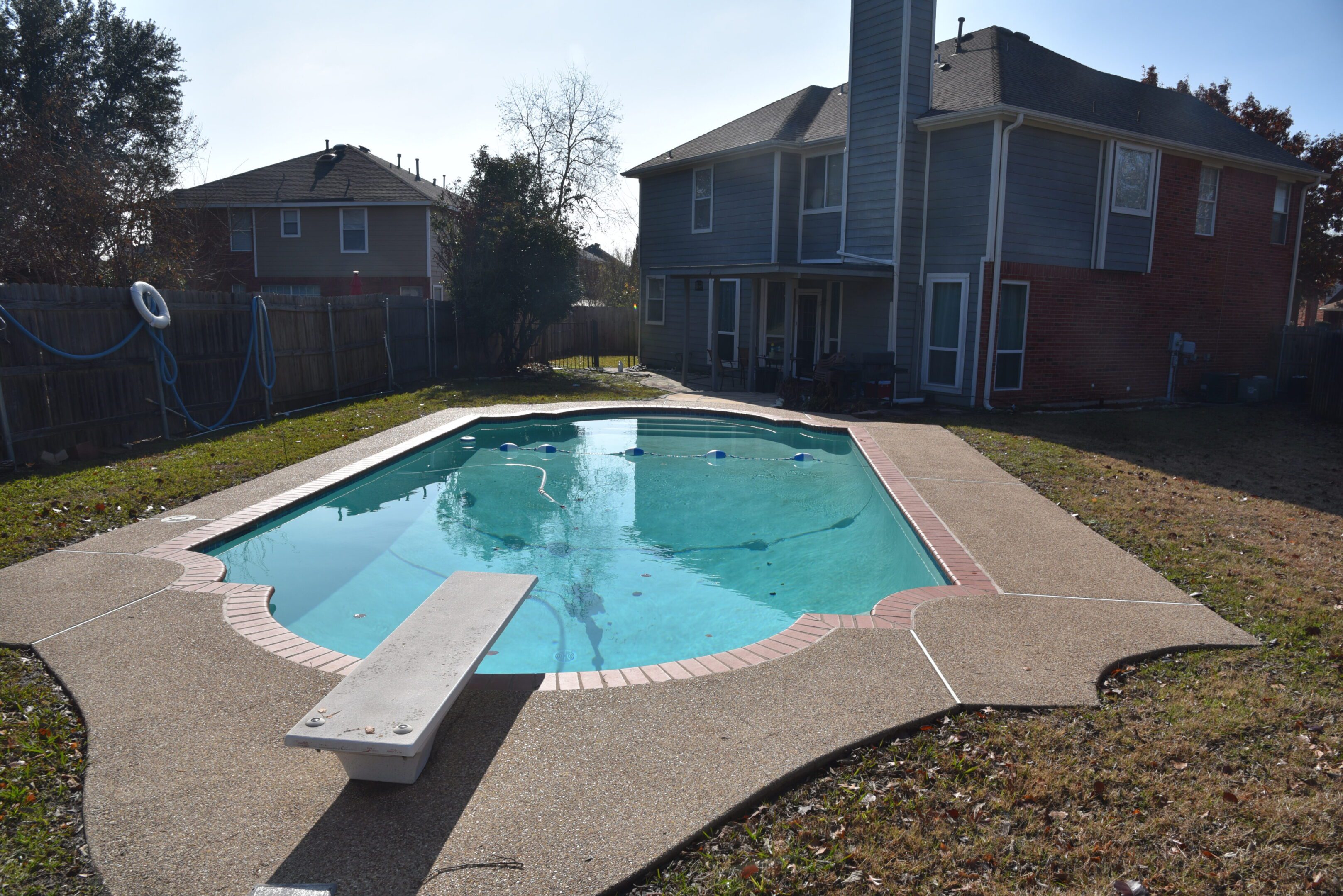 Backyard swimming pool with diving board.