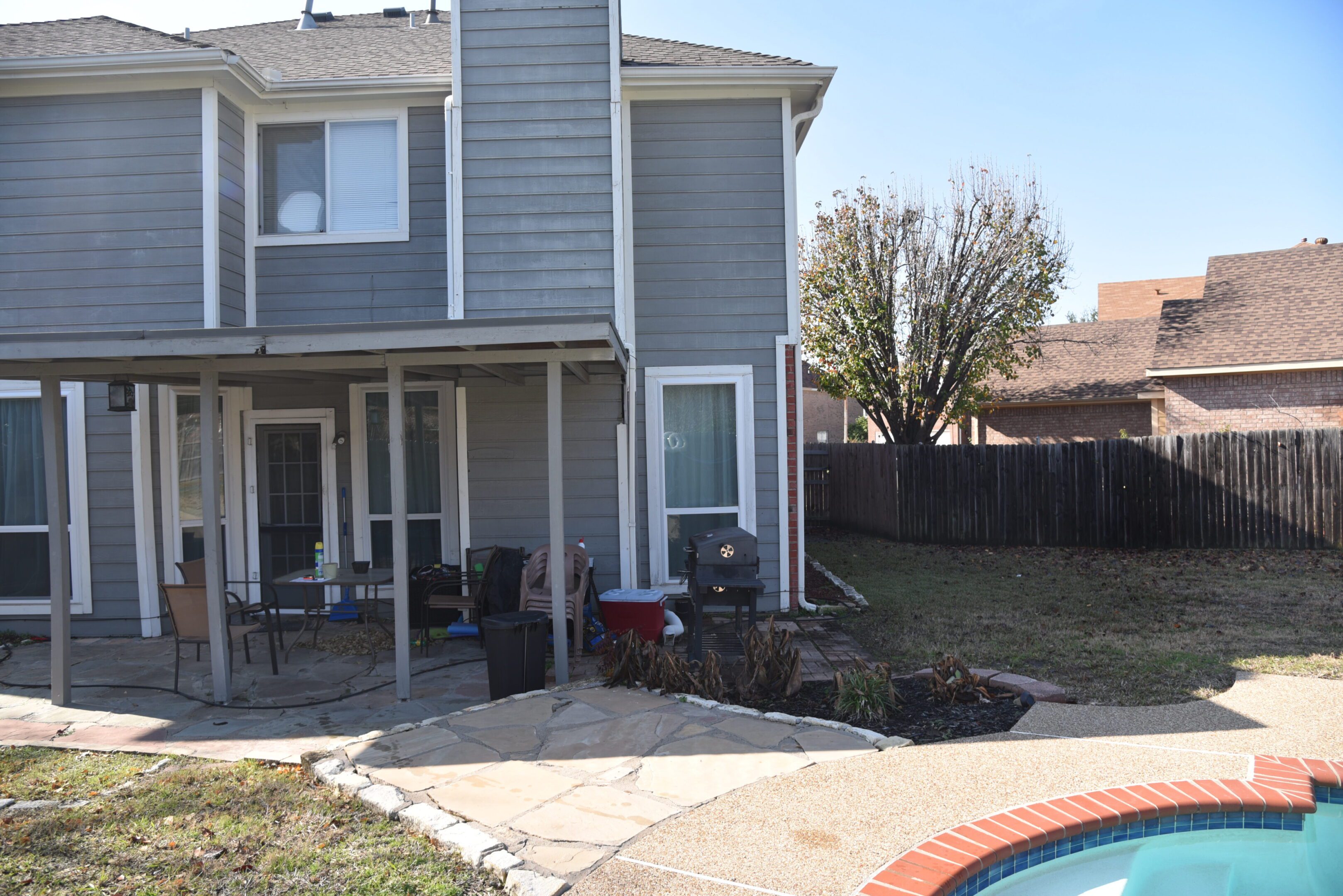 Gray house with backyard and swimming pool.