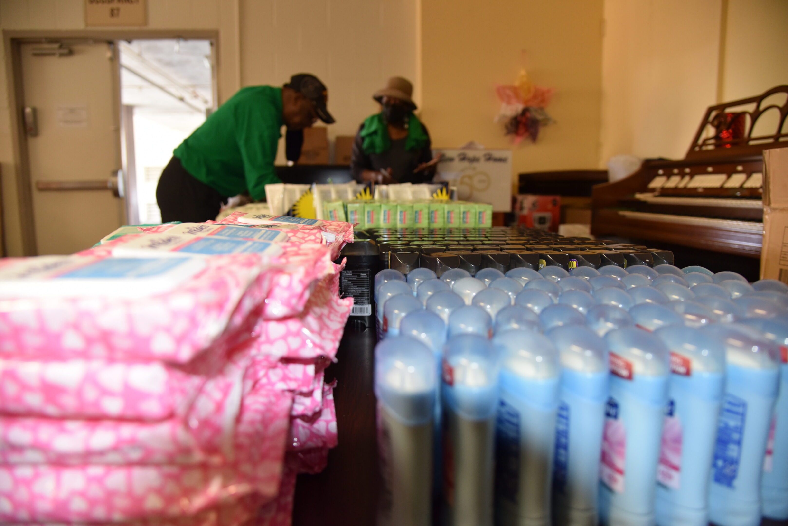 Table with toiletries and two people organizing.
