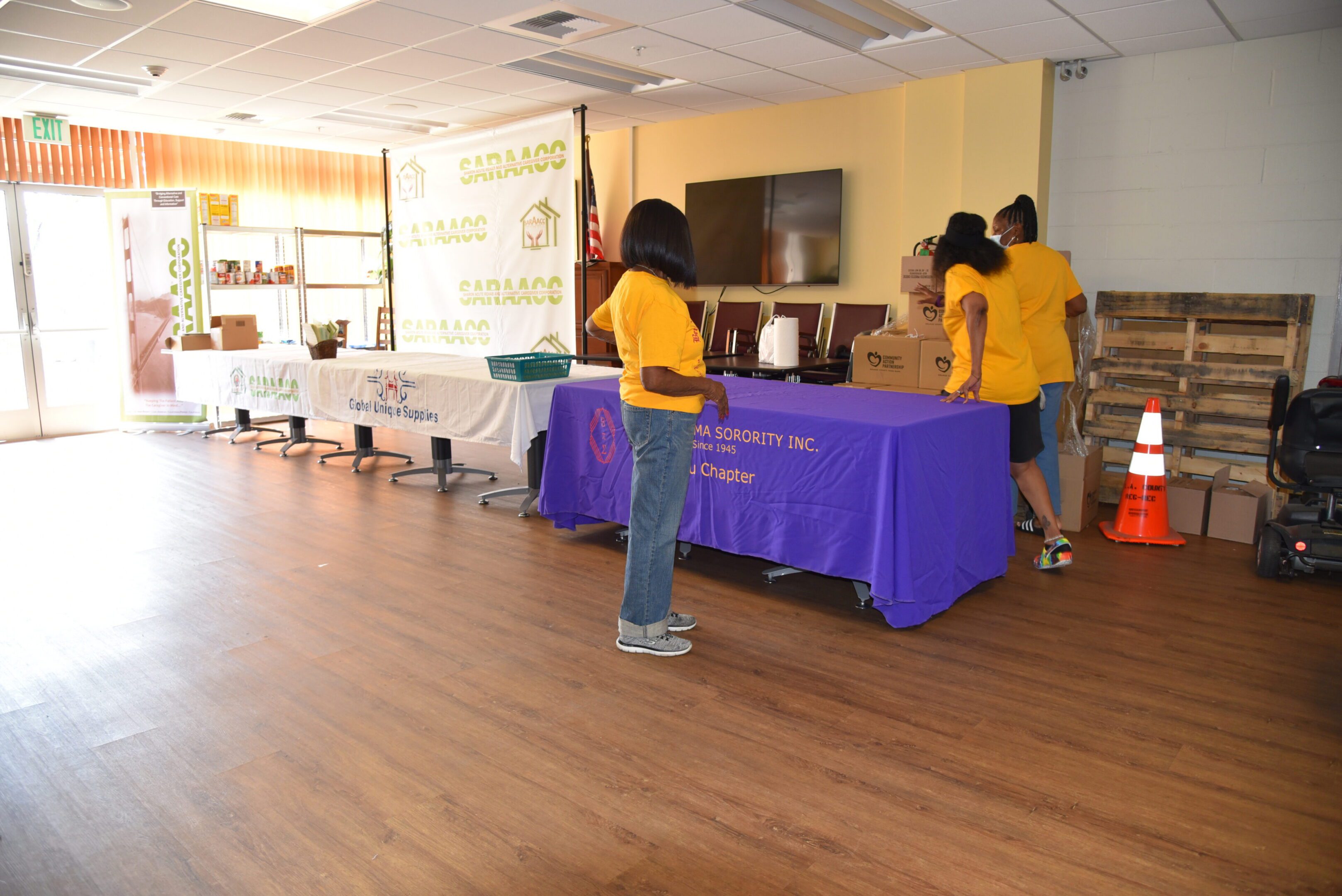 Volunteers setting up tables in community center.