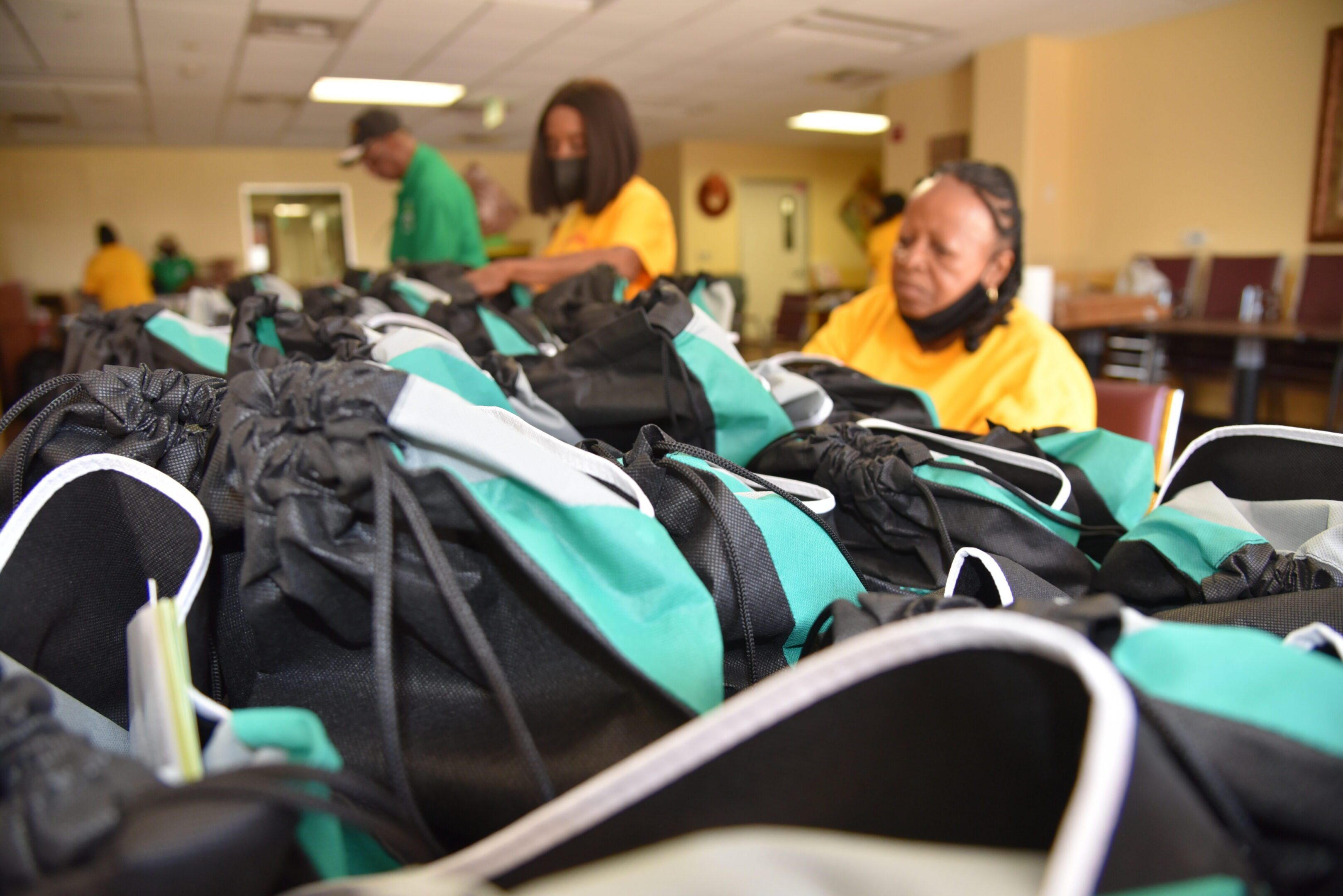 Volunteers sorting bags on a table.