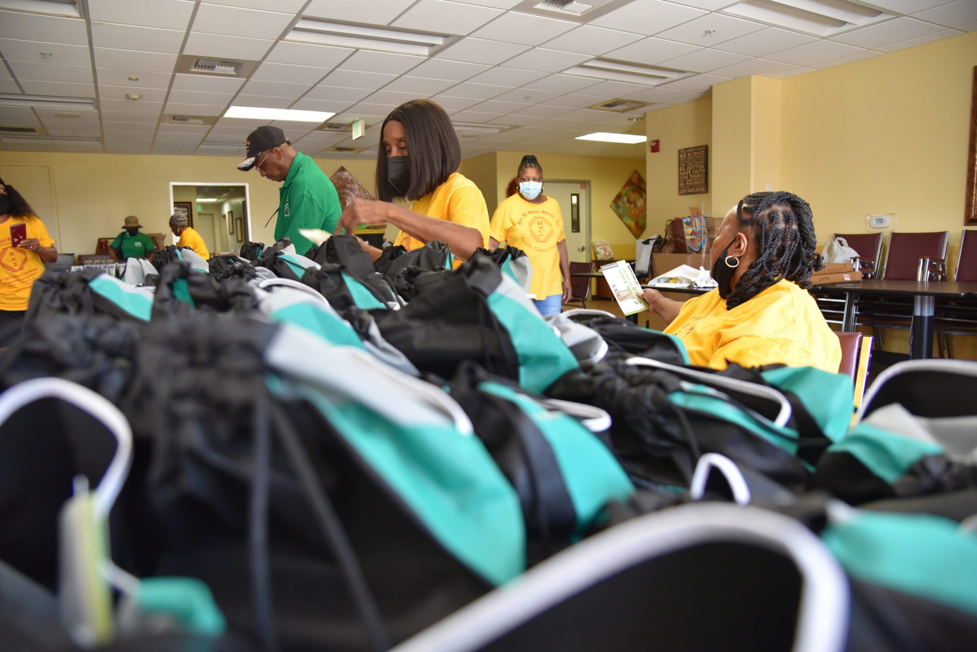 People assembling bags in a community center.