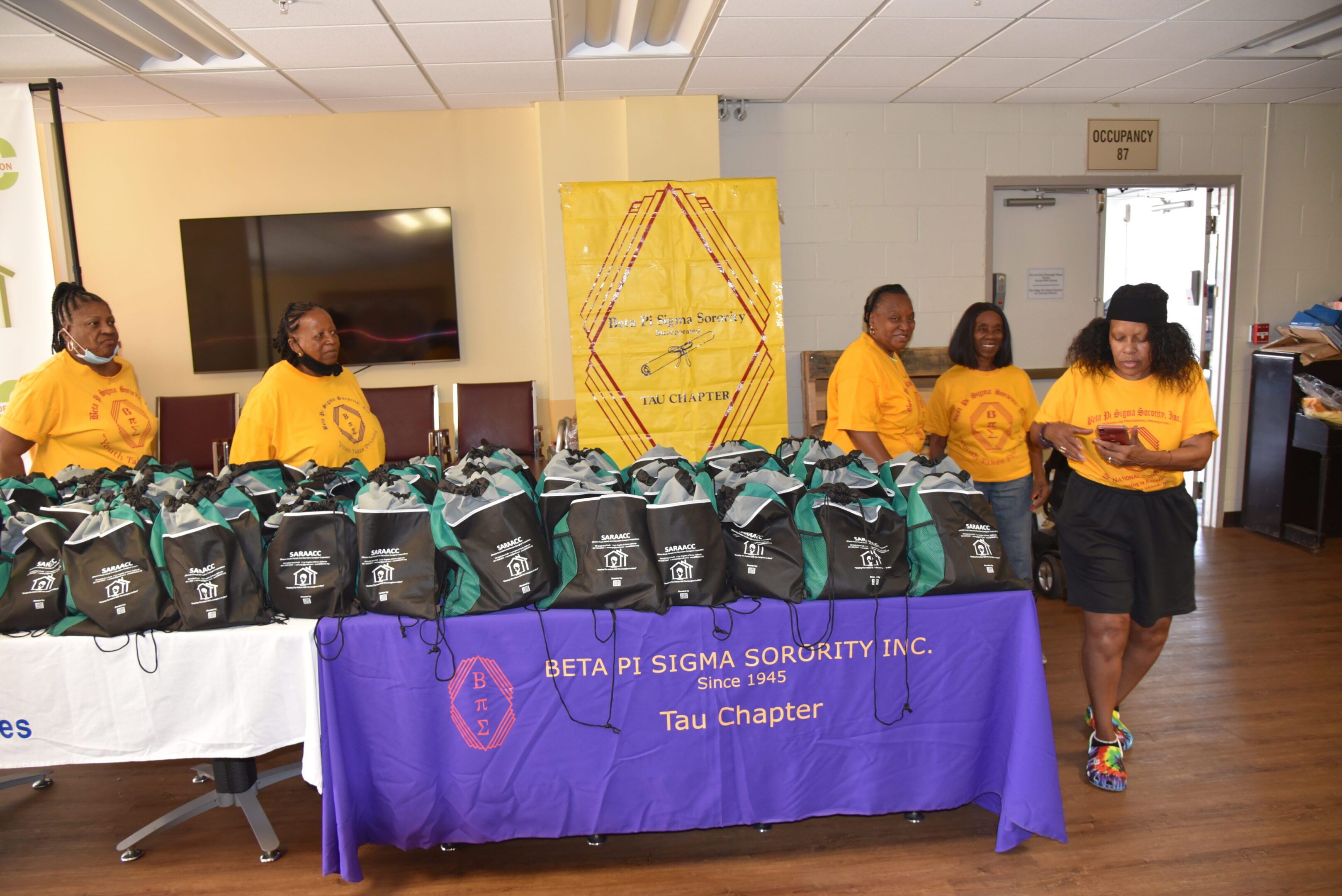 Sorority members with bags on display table.