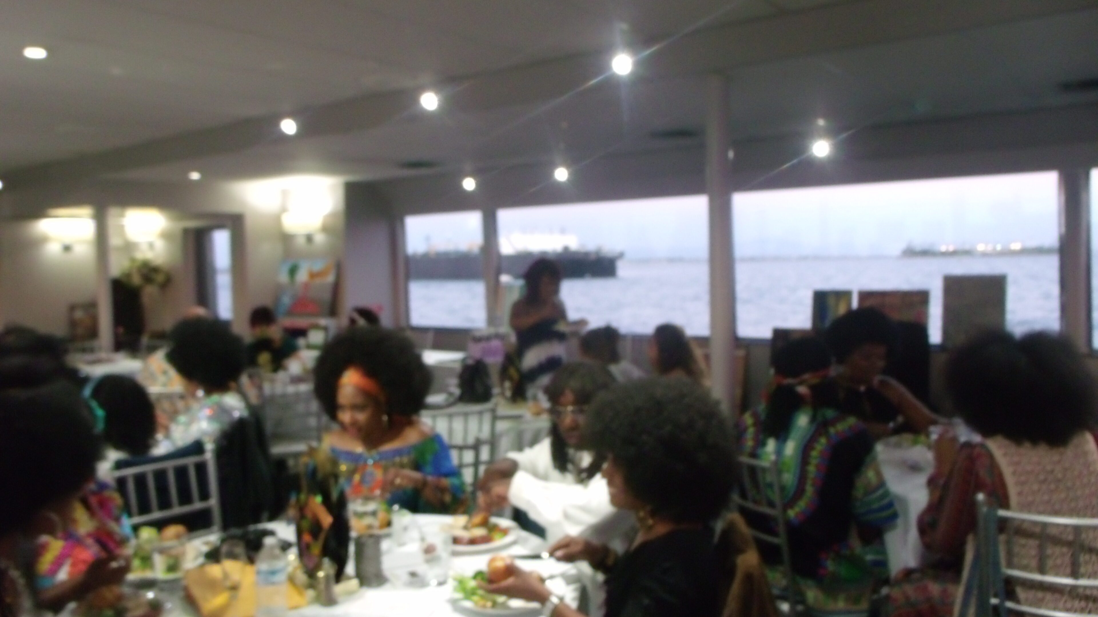 People dining at a waterfront restaurant event.