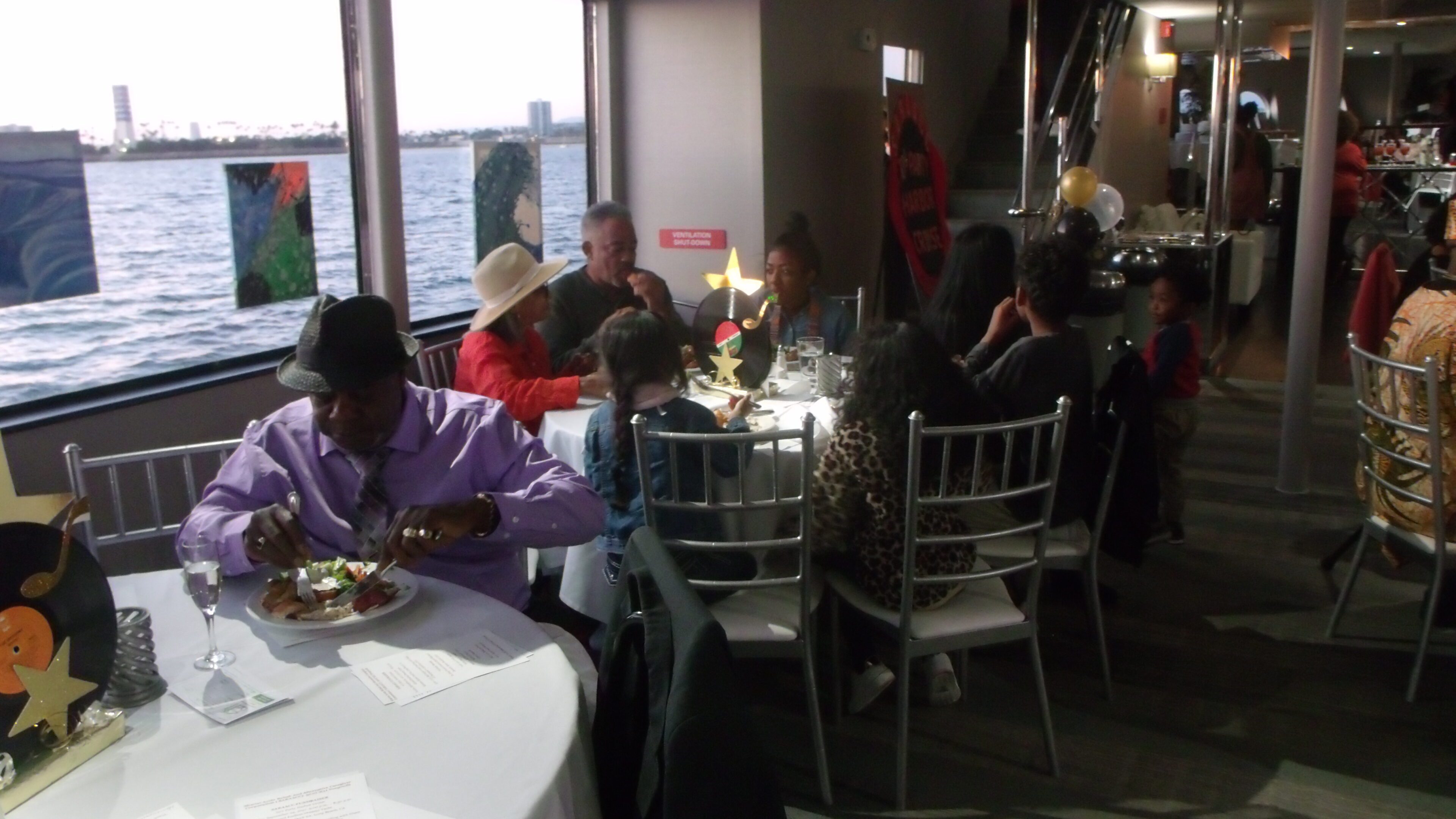 People dining on a boat near water.