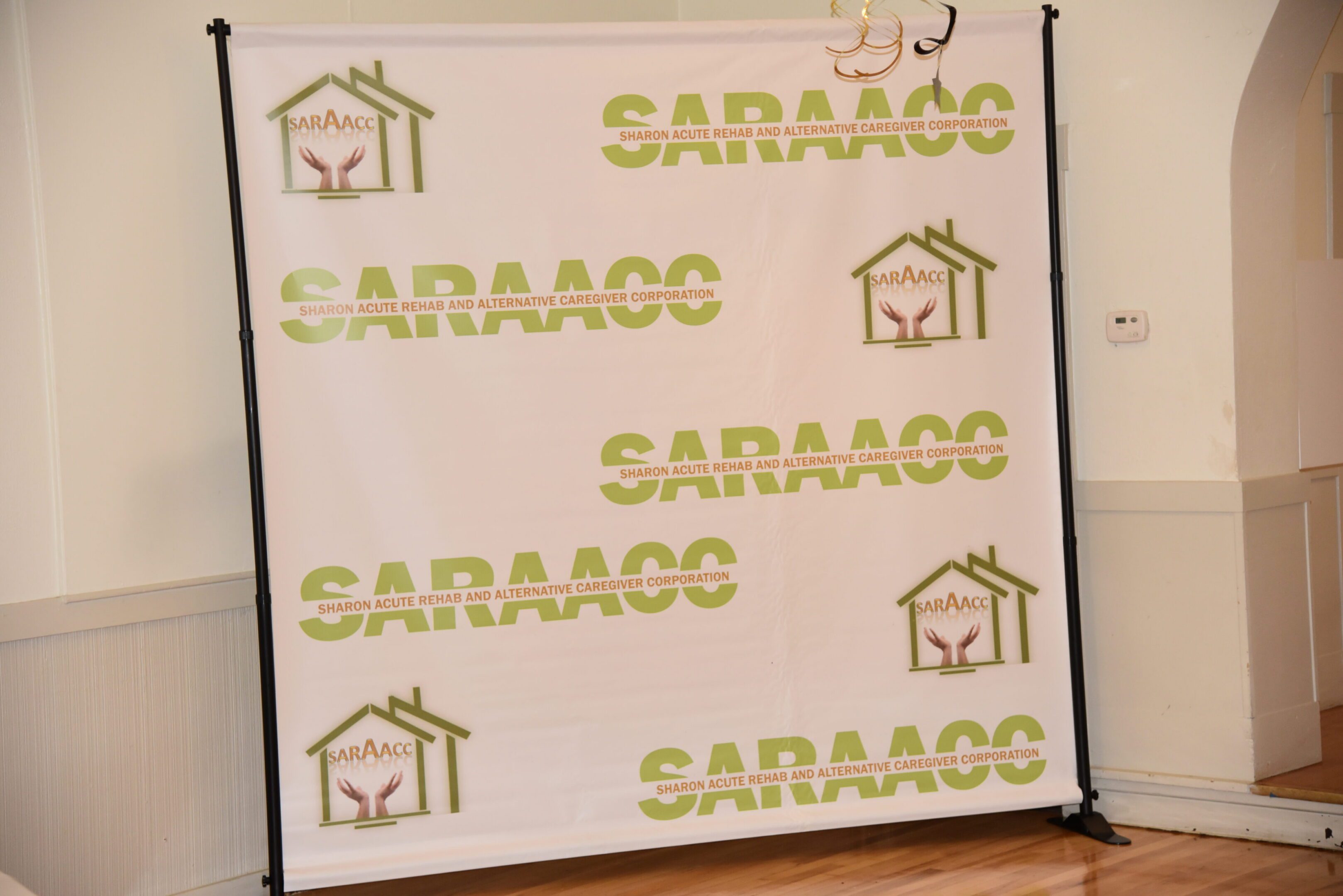 SARAAC backdrop with logos and text.