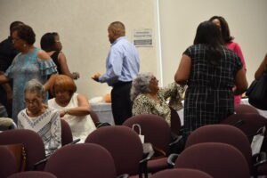 People socializing in a conference room setting.