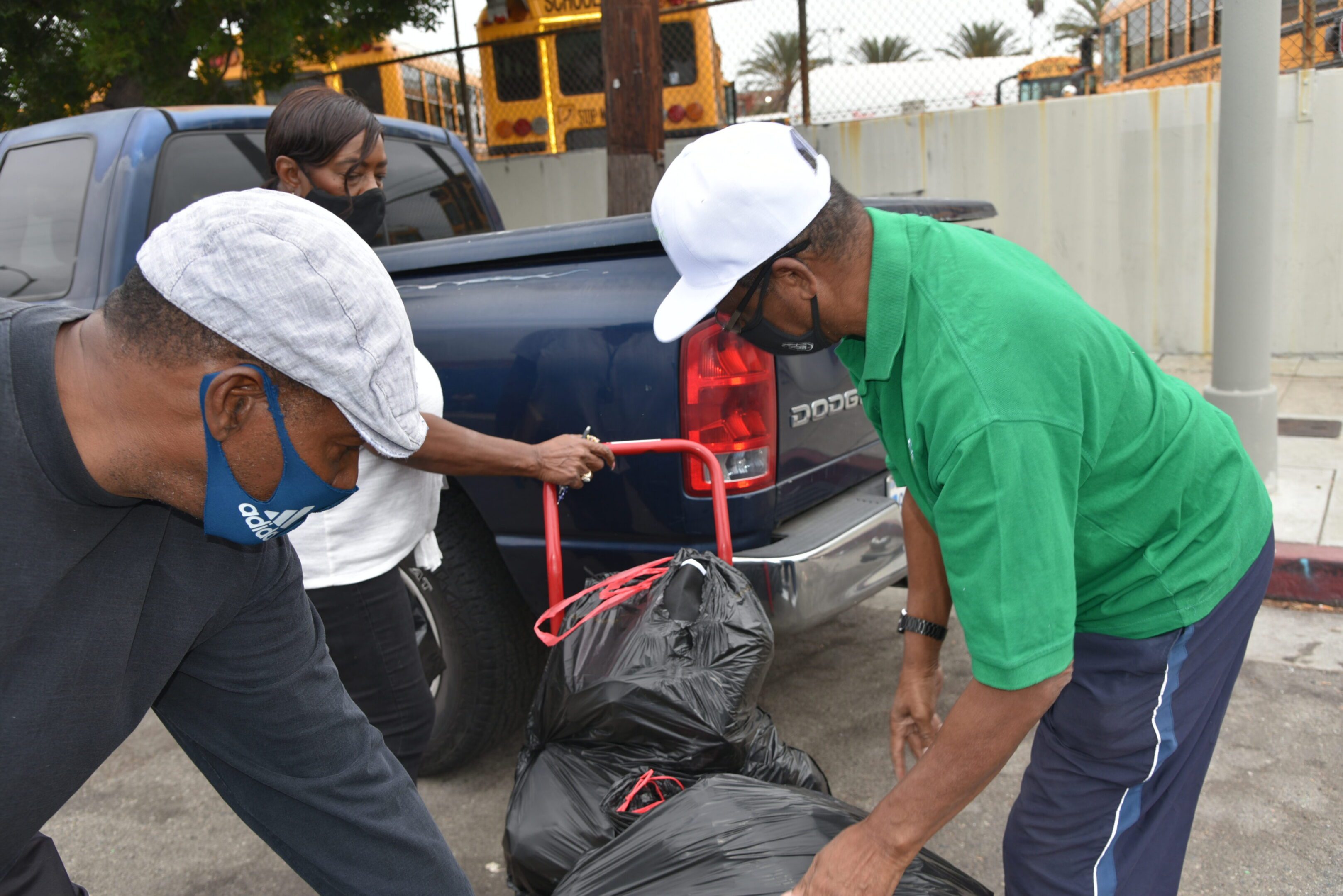 People loading garbage bags into a truck.