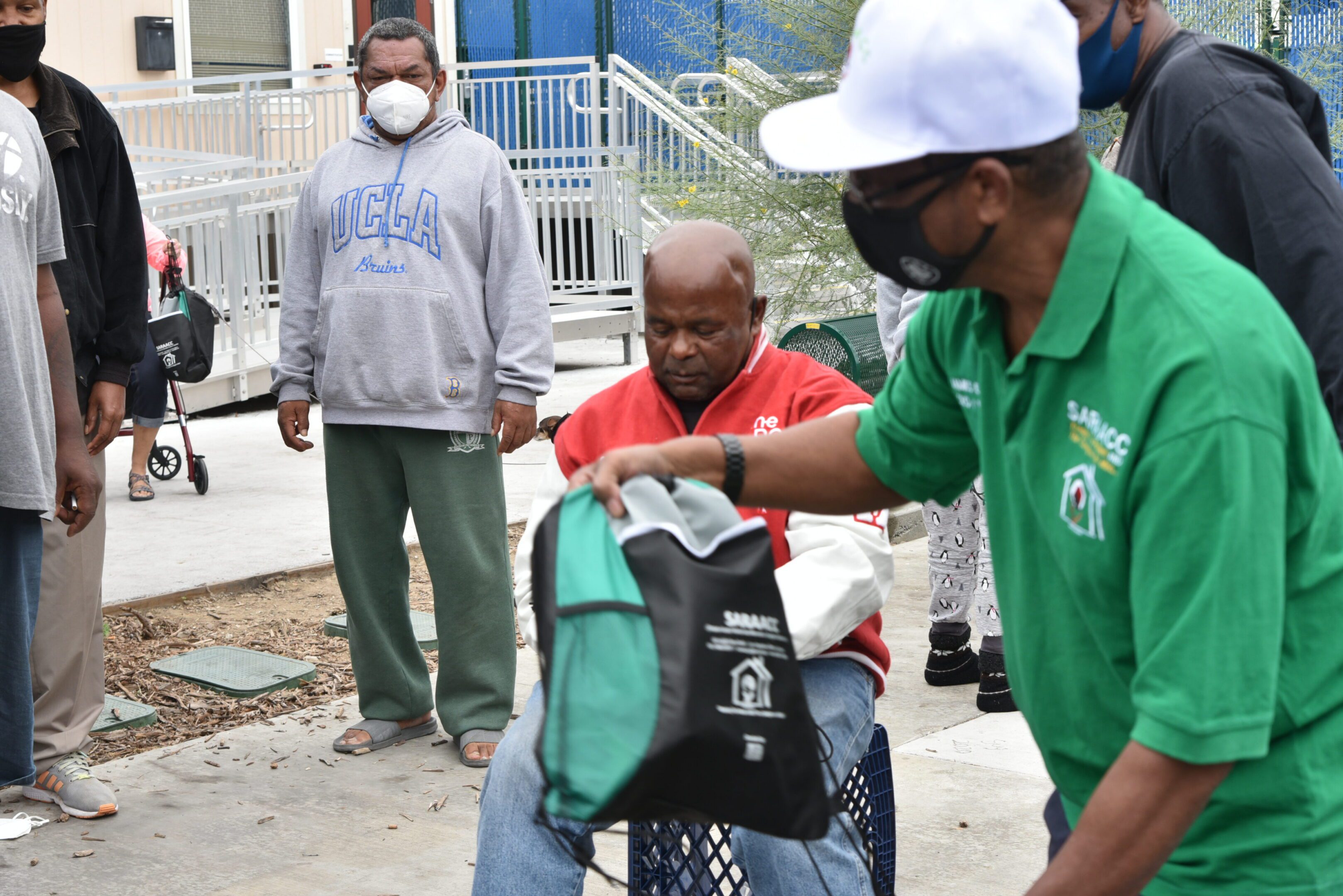 People distributing bags at an outdoor event.