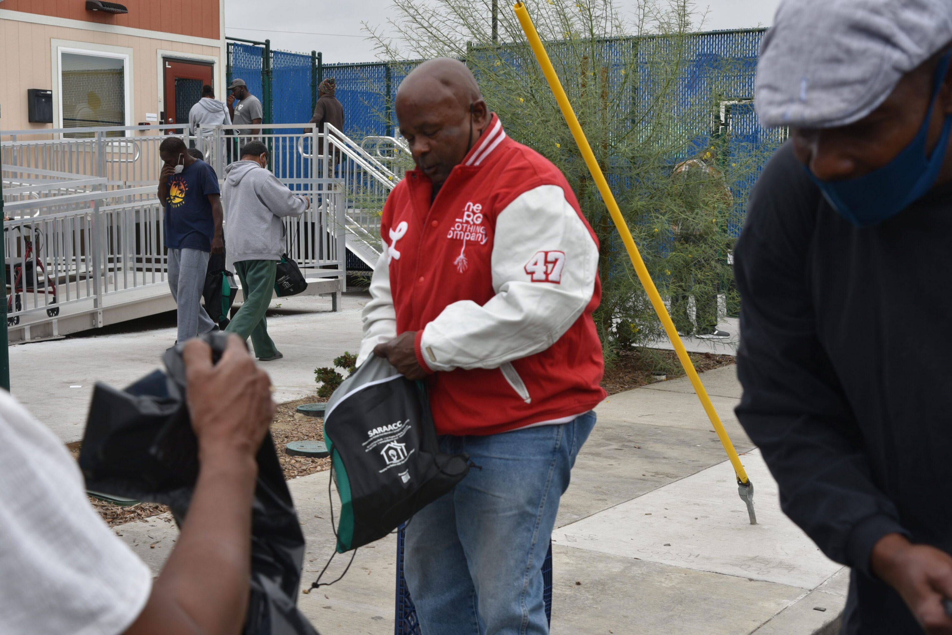 People distributing and receiving bags outdoors.