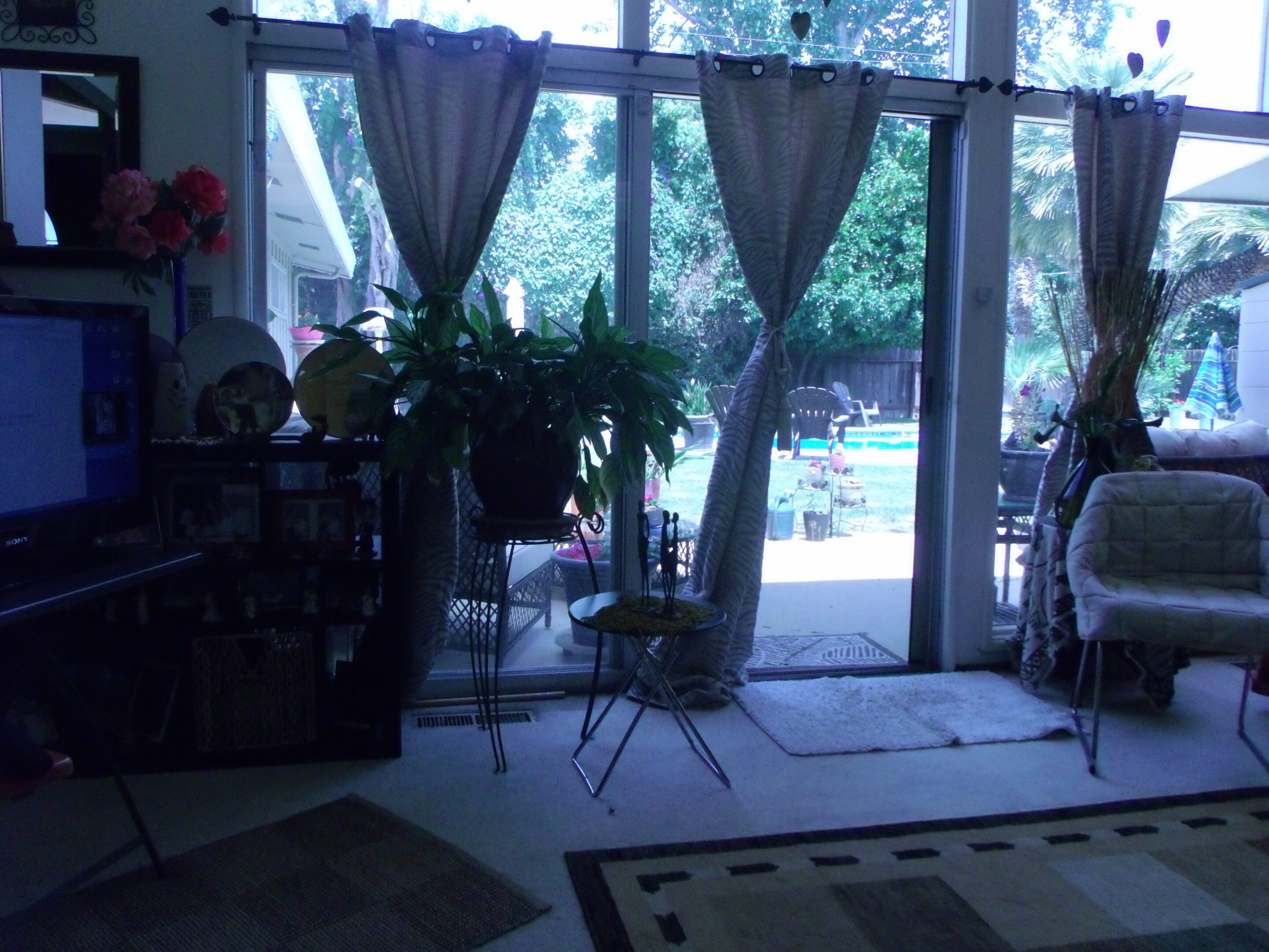 Living room with glass doors, pool outside.