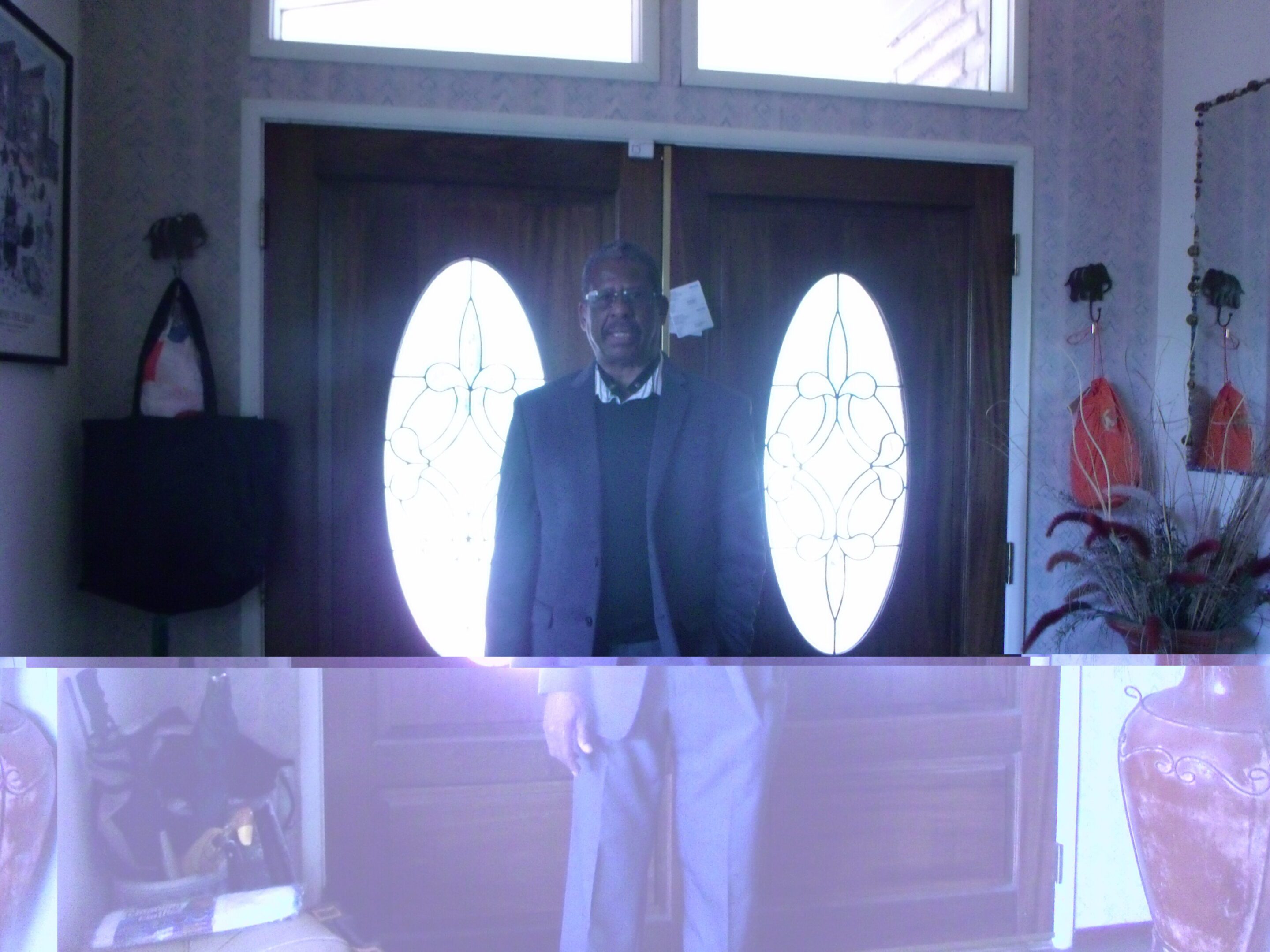 Man standing near decorative wooden doors.