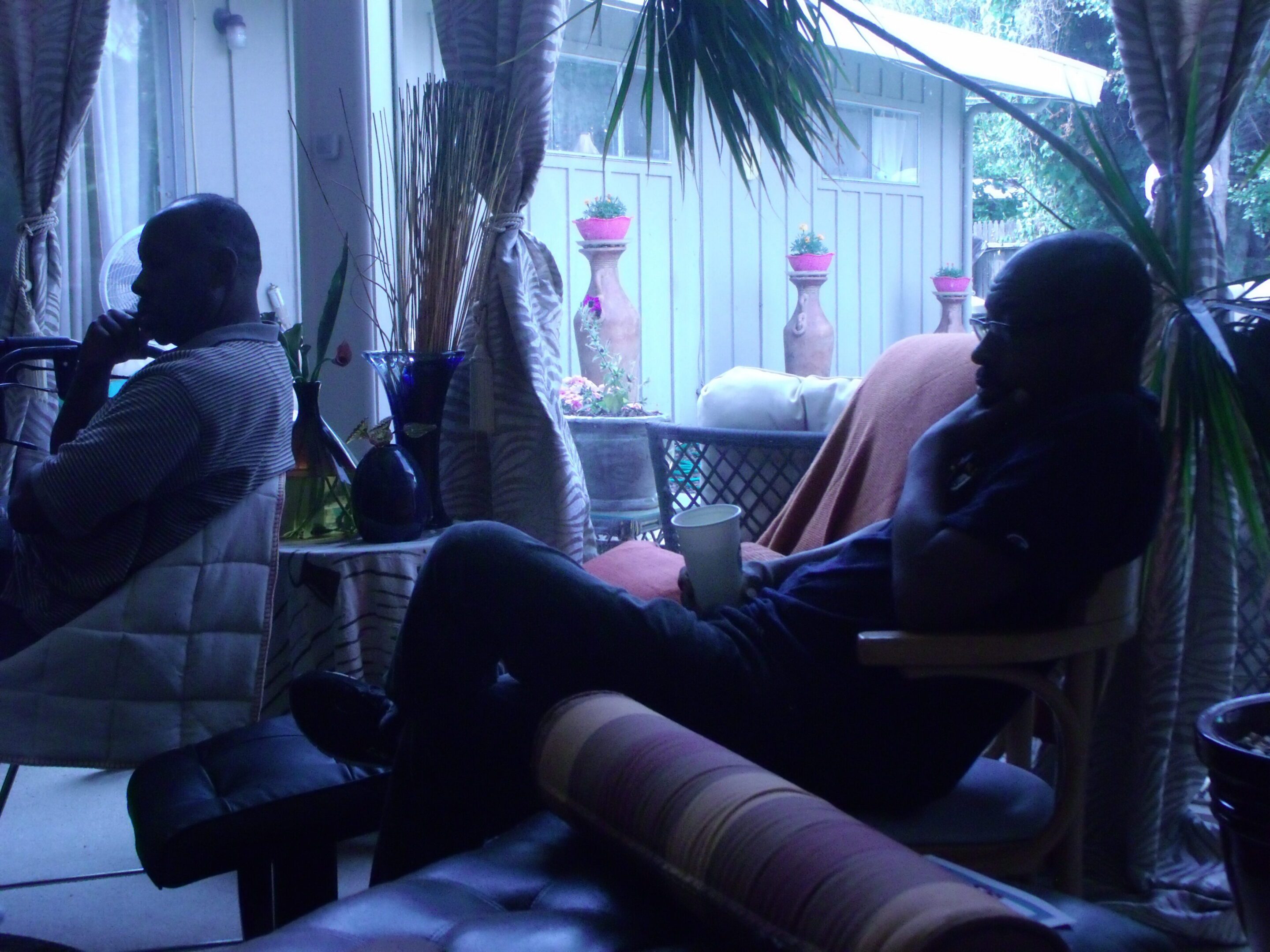 Two people sitting in a dimly lit room.