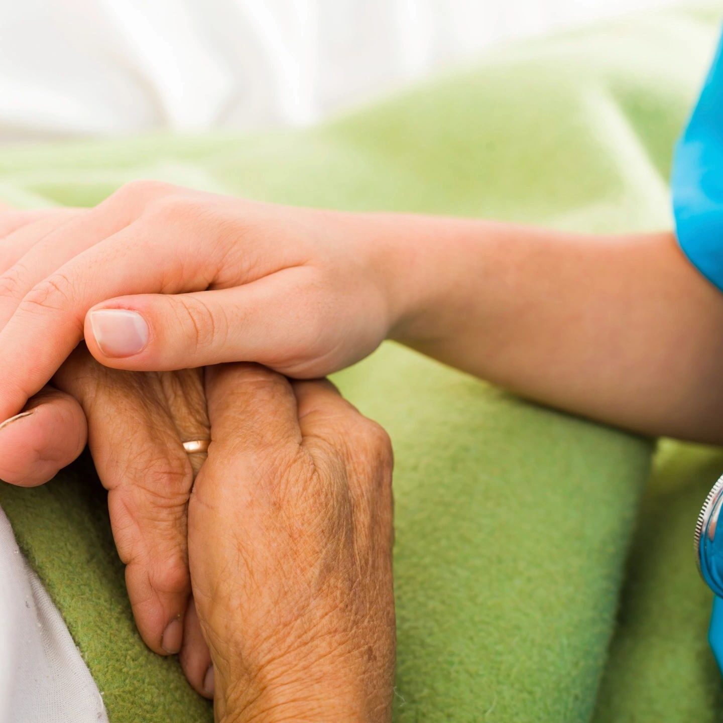 Nurse holding patient's hand for support.